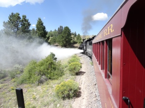 A "blowdown" - when steam is ejected from the boiler to clean out contaminants (dirt, etc.) that would otherwise build up. Inevitably, the breeze would blow the cooled-off steam back on the folks in the gondola.